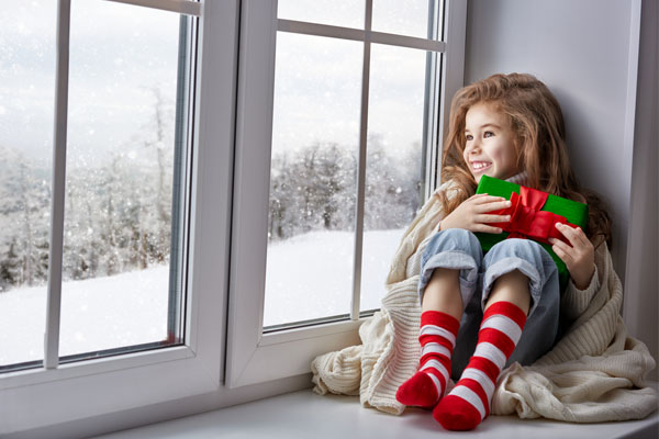 image of girl sitting in window in warm house in winter