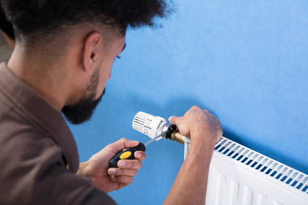 image of an hvac contractor tuning up oil heat hydronic heating system