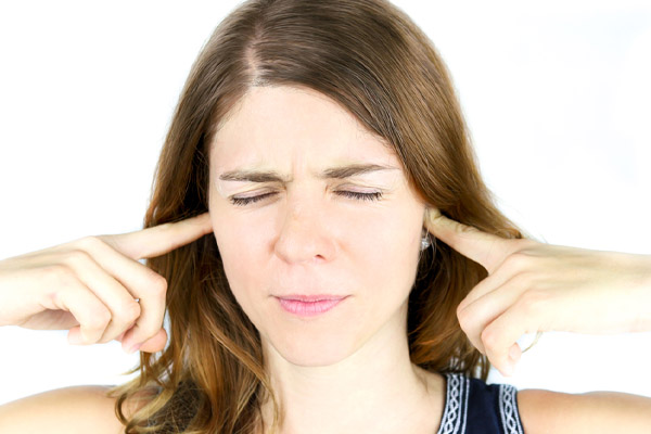 image of homeowner covering ears due to air conditioner noises