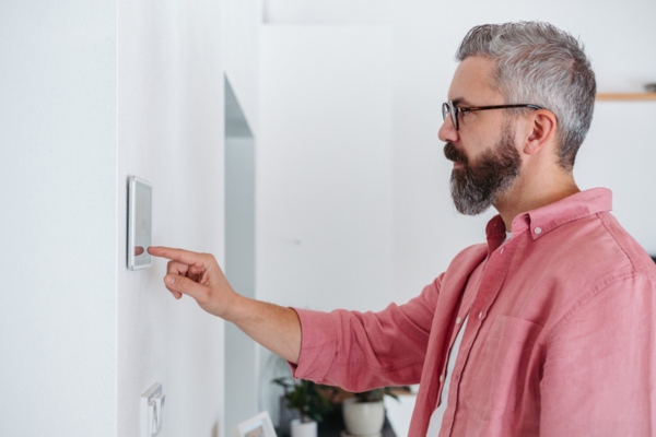 Man using smart thermostat for energy efficiency in winter